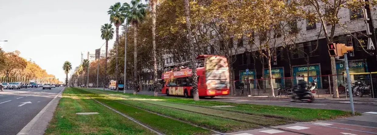 Vista exterior de la Avinguda Diagonal frente a L'Illa Coworking en Barcelona con palmeras y tranvía
